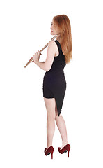 Image showing Woman standing from back, holding her flute