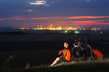 Image showing guy has a rest sitting near his bike