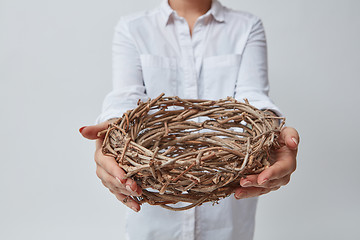 Image showing Girl gives a nest of twigs