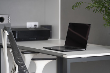 Image showing Home office with up-to-date equipment for a comfortable work. New modern notebook, up-to-date equipment on a table.