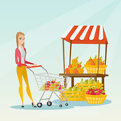 Image showing Young caucasian woman pushing a supermarket cart.