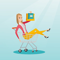 Image showing Young caucasian woman riding in shopping trolley.