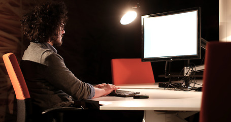 Image showing man working on computer in dark office