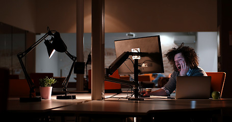 Image showing man working on computer in dark office