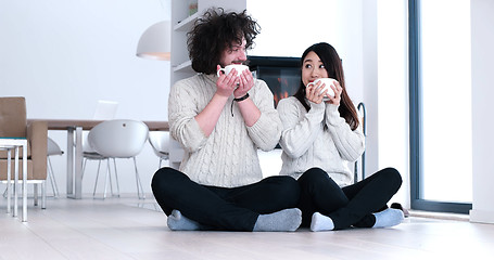 Image showing multiethnic romantic couple  in front of fireplace