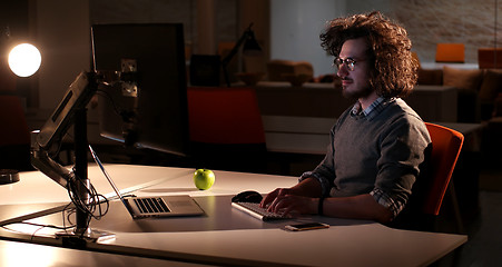 Image showing man working on computer in dark office