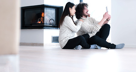 Image showing Young Couple using digital tablet on the floor