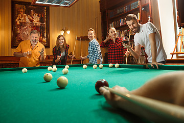 Image showing Young men and women playing billiards at office after work.