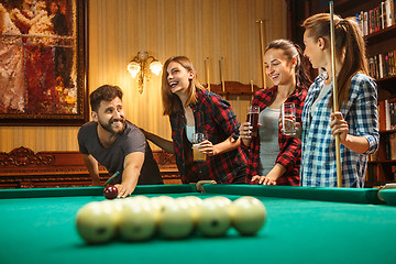 Image showing Young men and women playing billiards at office after work.