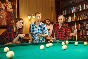 Image showing Young men and women playing billiards at office after work.