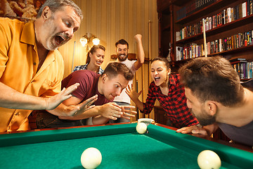 Image showing Young men and women playing billiards at office after work.