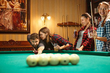 Image showing Young men and women playing billiards at office after work.