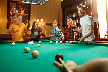 Image showing Young men and women playing billiards at office after work.