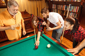 Image showing Young men and women playing billiards at office after work.