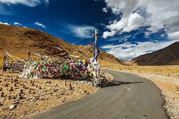 Image showing Road and Buddhist prayer flags lungta at Namshang La pass. Lad