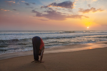 Image showing Young sporty fit woman doing yoga Sun salutation Surya Namaskar 