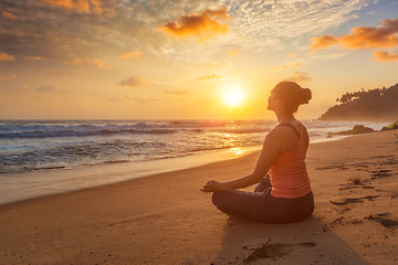 Image showing Woman doing yoga oudoors at beach - Padmasana lotus pose