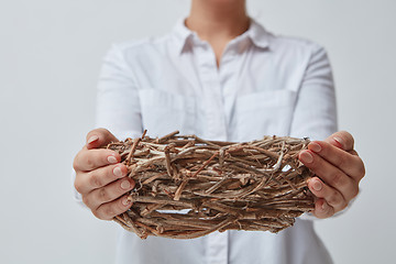 Image showing Girl gives an empty nest of branches