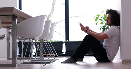 Image showing young man using a tablet at home