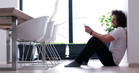 Image showing young man using a tablet at home