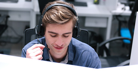 Image showing male call centre operator doing his job