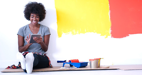 Image showing black female painter sitting on floor