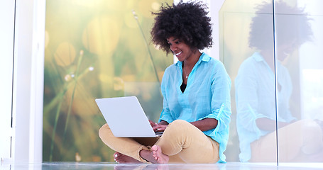Image showing black women using laptop computer on the floor