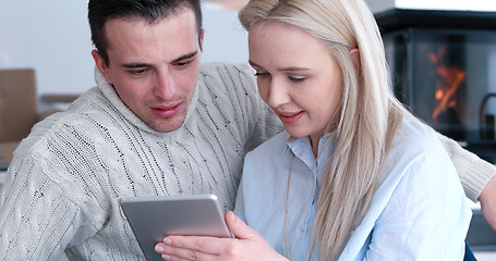 Image showing Young Couple using digital tablet on the floor