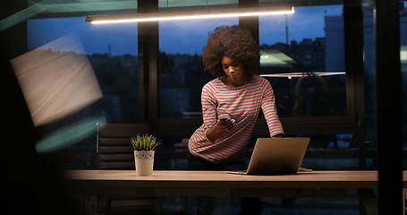 Image showing black businesswoman using a laptop in night startup office