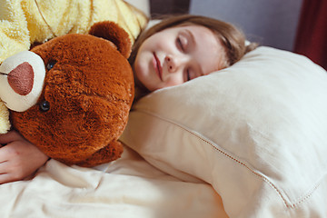 Image showing child little girl sleeps in the bed with a toy teddy bear