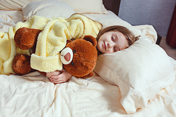 Image showing child little girl sleeps in the bed with a toy teddy bear