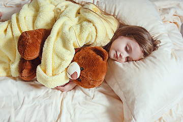 Image showing child little girl sleeps in the bed with a toy teddy bear
