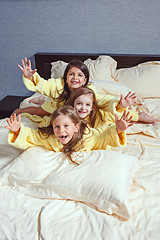 Image showing The group of girlfriends taking goog time on bed