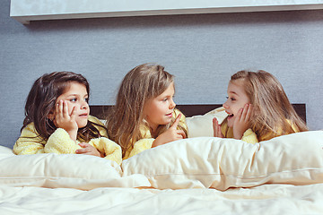 Image showing The group of girlfriends taking goog time on bed