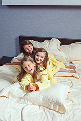 Image showing The group of girlfriends taking goog time on bed