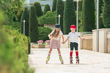 Image showing Portrait of a charming teenage couple roller-skating together