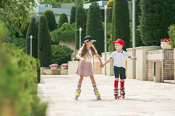 Image showing Portrait of a charming teenage couple roller-skating together