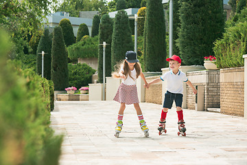 Image showing Portrait of a charming teenage couple roller-skating together