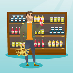 Image showing Man holding shopping basket and bottle of sauce.