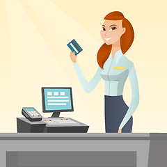 Image showing Caucasian cashier holding a credit card.