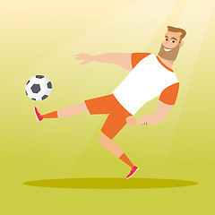 Image showing Young caucasian soccer player kicking a ball.