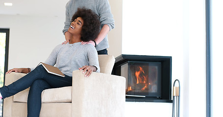 Image showing multiethnic couple hugging in front of fireplace