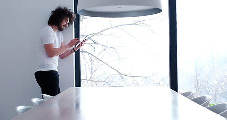 Image showing young man using a tablet at home