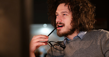 Image showing man working on computer in dark office