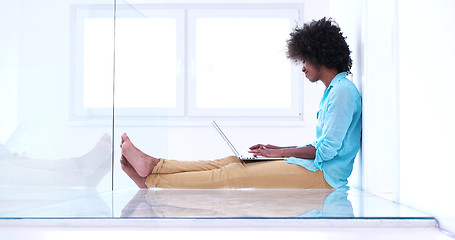Image showing black women using laptop computer on the floor