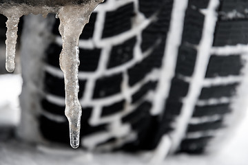 Image showing closeup of a tyre of a car with icicle