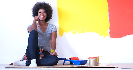 Image showing black female painter sitting on floor