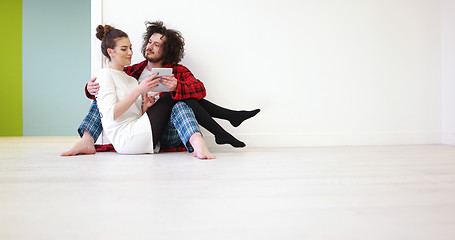 Image showing Young Couple using digital tablet on the floor