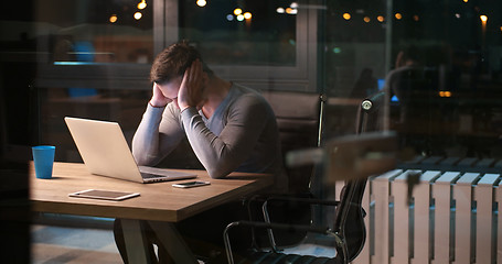 Image showing man working on laptop in dark office