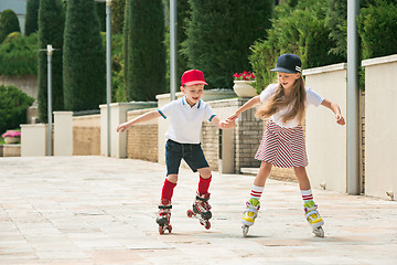 Image showing Portrait of a charming teenage couple roller-skating together